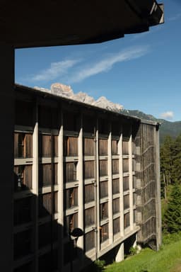 Die Gitterfassade des Hotel Boite, dahinter die Dolomiten