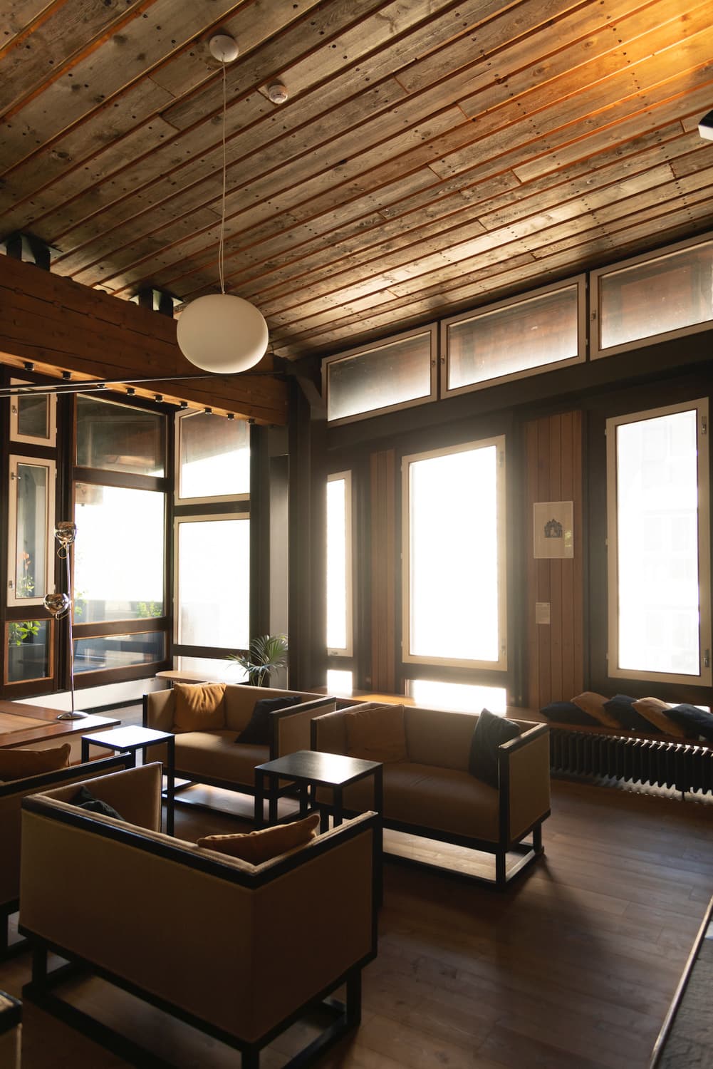 Der Gemeinschaftsraum des Hotel Boite: Originaleinrichtung, Holzdecke und Kugelleuchte
