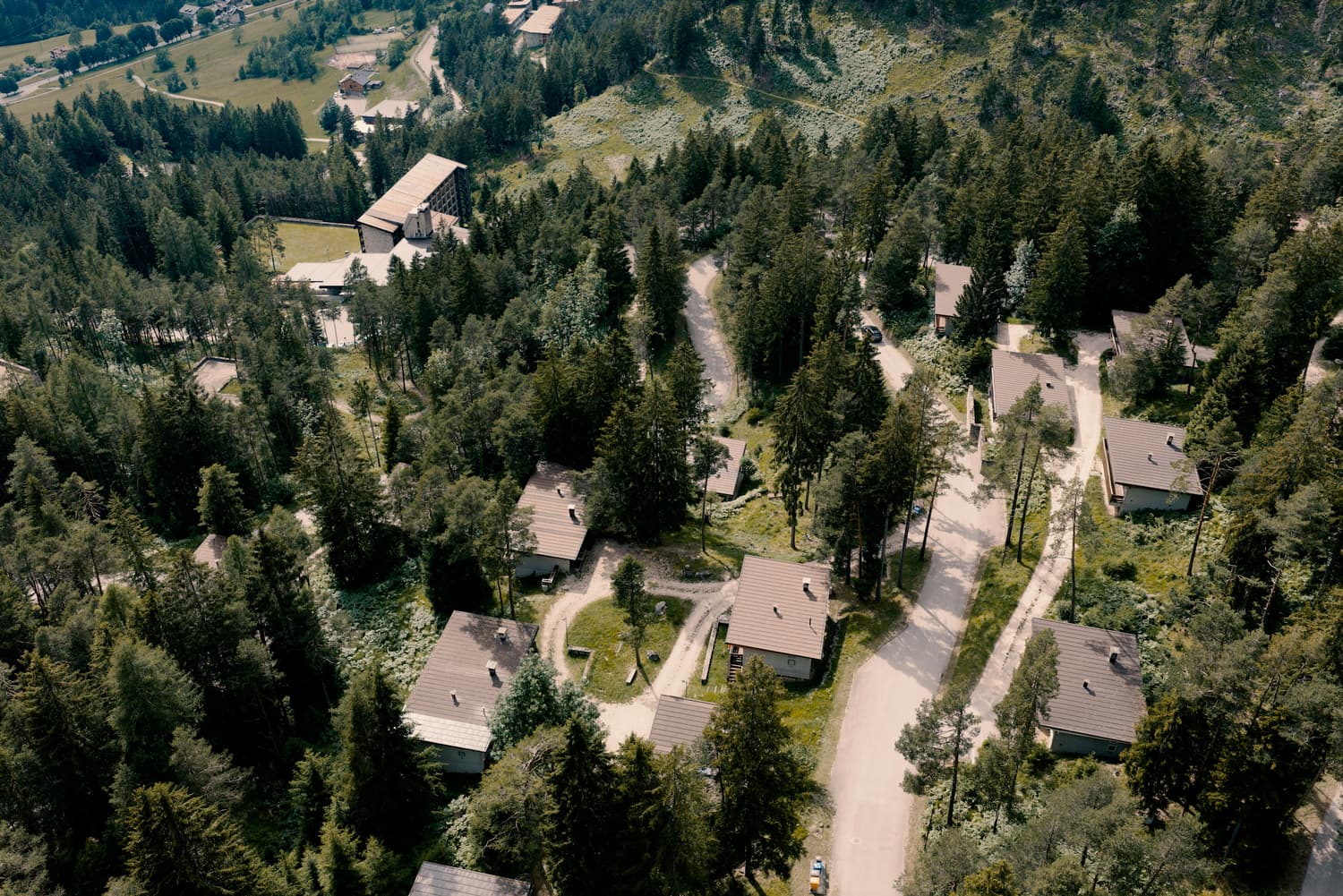Luftaufnahme des ehemaligen Villaggio Eni: die Straßen, die zwischen den Gebäuden durch den Wald führen