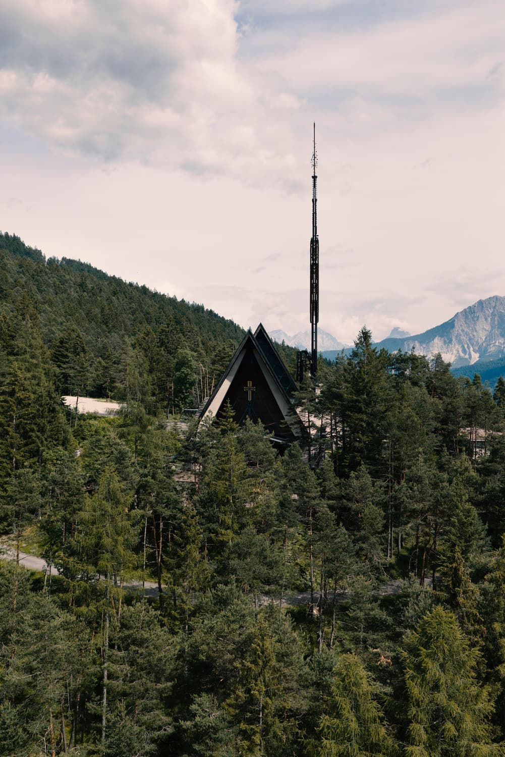 Die von Edoardo Gellner entworfene Kirche, ihr Glockenturm zwischen den Tannen