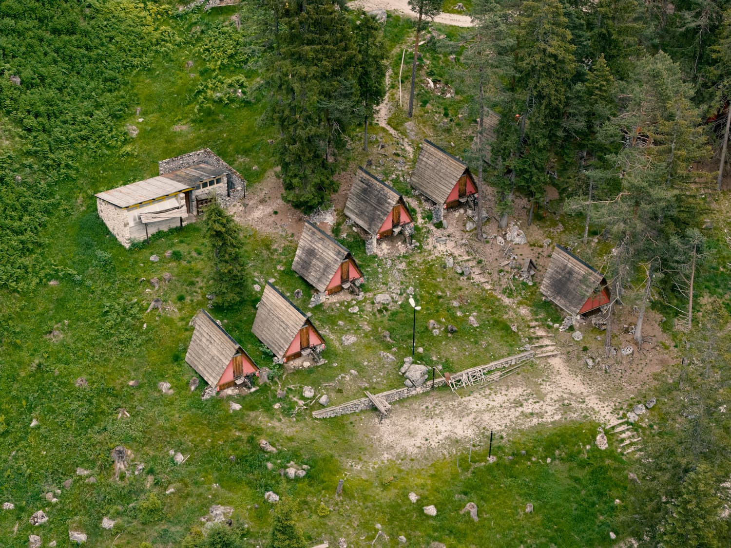 Die Häuser des Villaggio Eni zwischen Lichtung und Kiefernwald